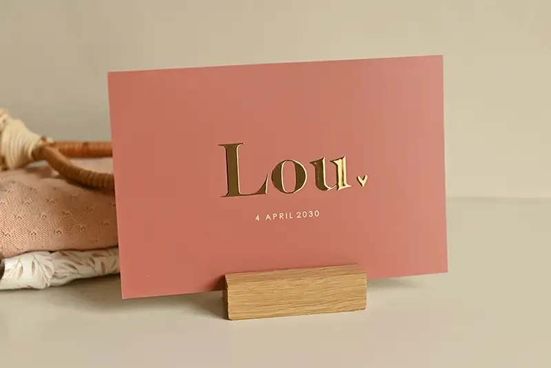 Minimalistisch geboortekaartje van goudfolie op roestbruin unisex